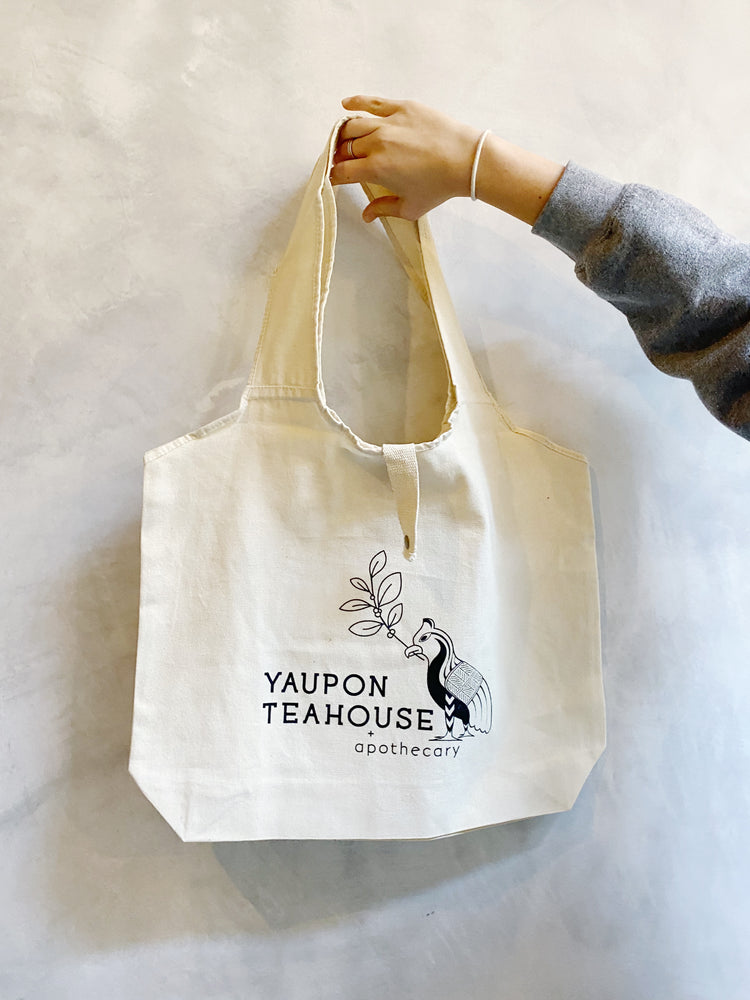 
            
                Load image into Gallery viewer, Yaupon Teahouse canvas tote bag with snap closure and wide straps
            
        